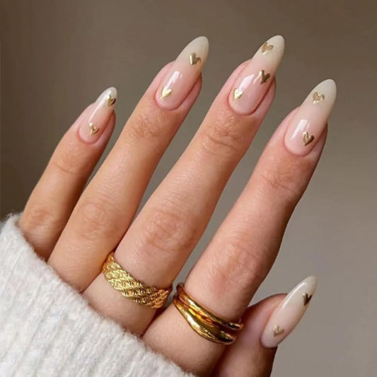 Nails with gold heart decorations on a neutral background