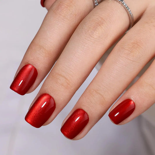 Hand with red nail polish on a neutral background
