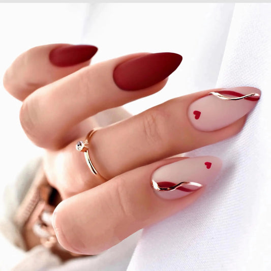 Close-up of a hand with red nail polish and heart designs on a white background